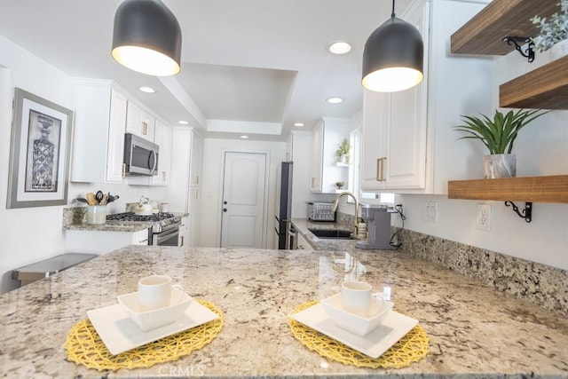 kitchen featuring stainless steel appliances, light stone counters, open shelves, and a sink