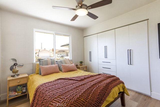 bedroom with ceiling fan, a closet, and light wood-style flooring