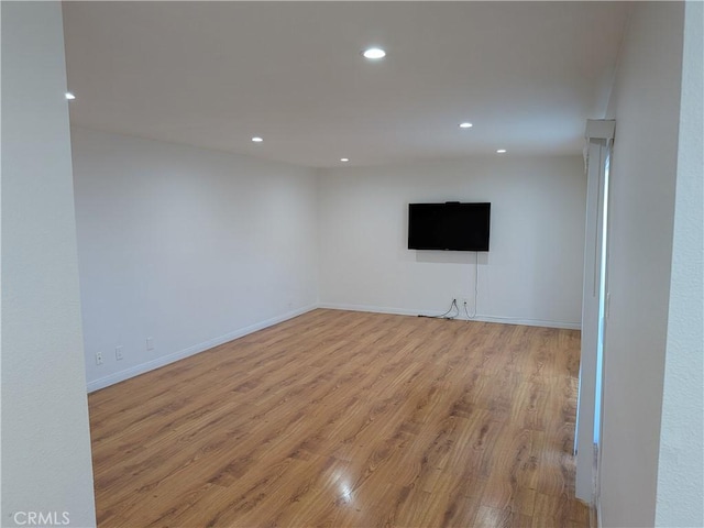 basement featuring baseboards, light wood-style flooring, and recessed lighting