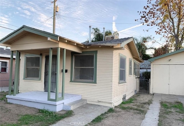 view of front of home featuring crawl space, fence, a chimney, and a gate