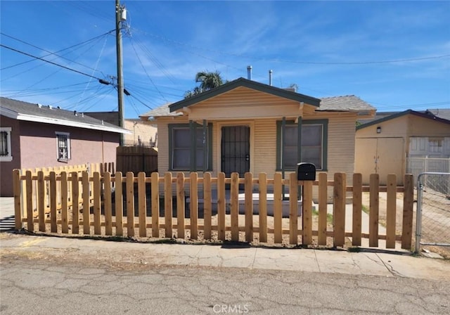 view of front of home with a fenced front yard and a gate