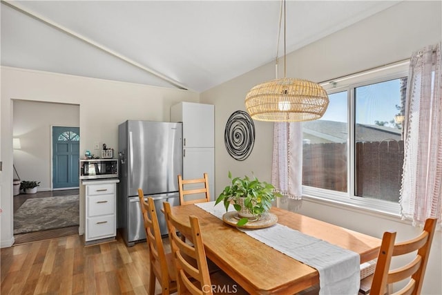 dining room with vaulted ceiling and wood finished floors