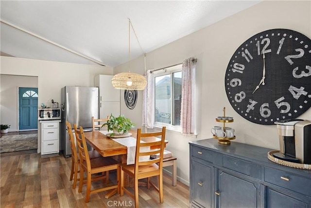 dining room with vaulted ceiling, dark wood finished floors, and baseboards