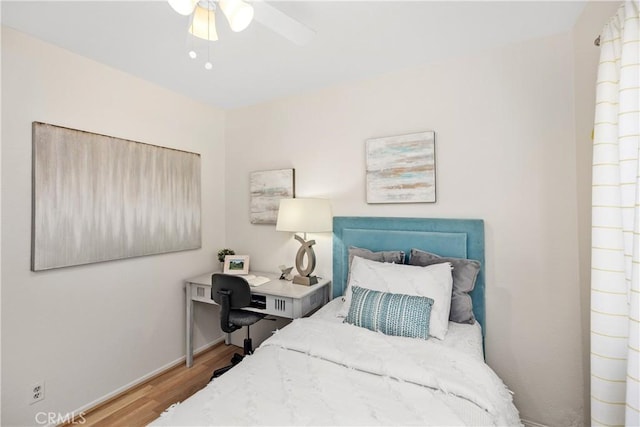 bedroom with light wood-type flooring, ceiling fan, and baseboards