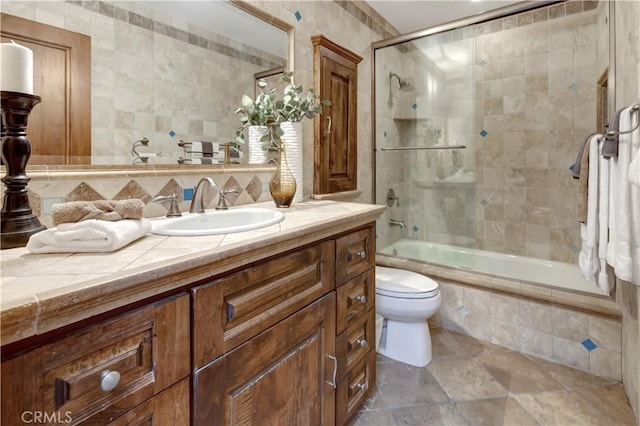 full bathroom with tiled shower / bath, toilet, tile walls, and vanity