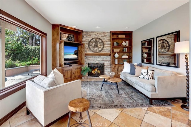 living room featuring baseboards, light tile patterned floors, a fireplace, and built in features