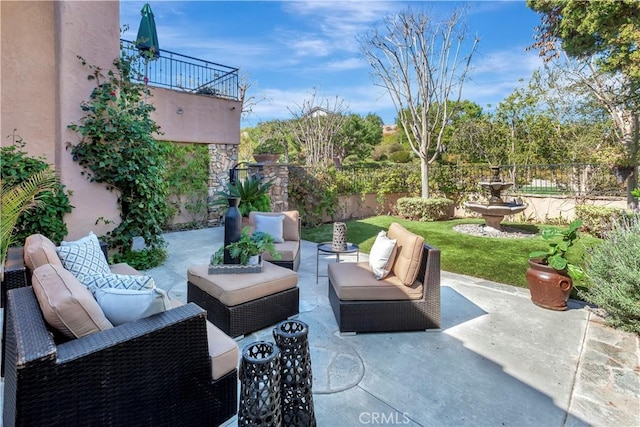 view of patio with a balcony, fence, and an outdoor hangout area