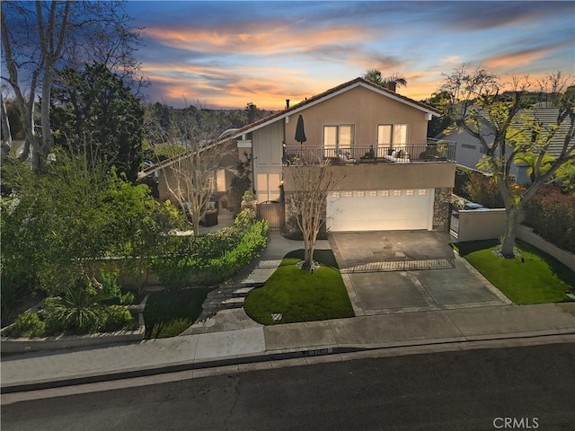 view of front facade with a garage, driveway, and stucco siding