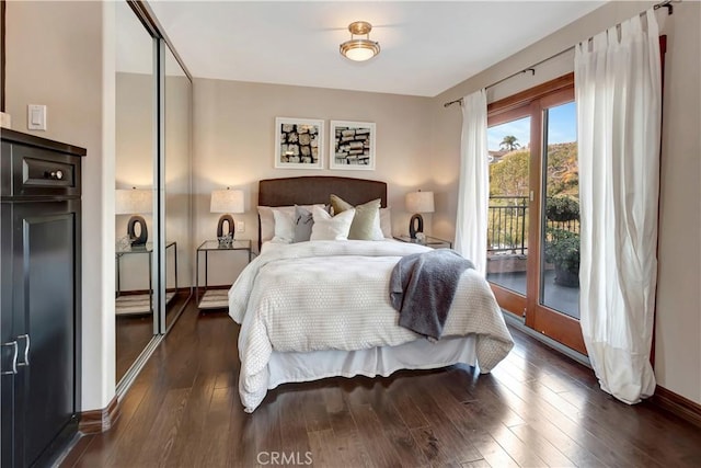 bedroom with access to outside, dark wood finished floors, and baseboards