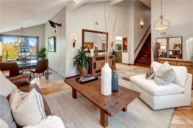 living area featuring light tile patterned floors, visible vents, baseboards, stairway, and high vaulted ceiling