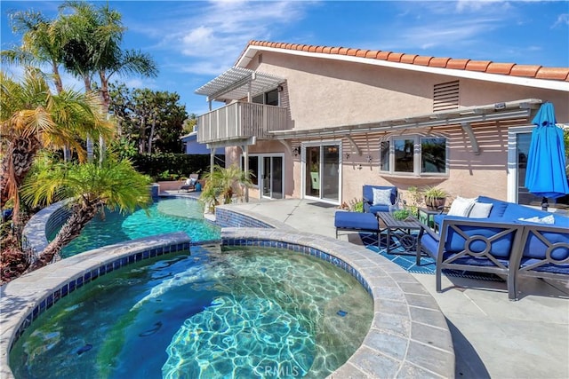 view of swimming pool featuring a patio, a pool with connected hot tub, and a pergola