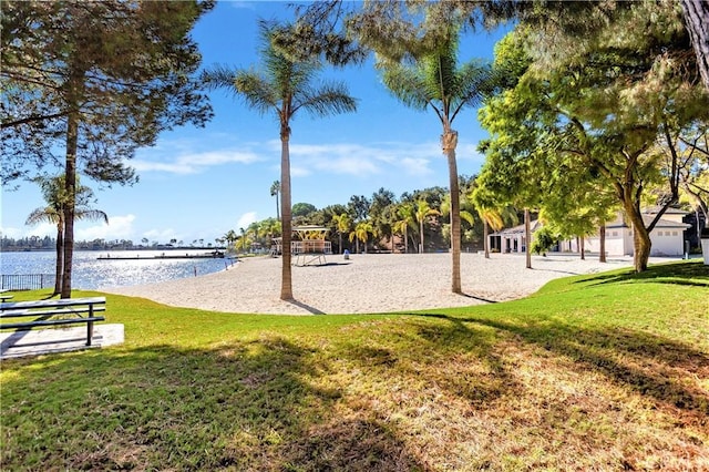 surrounding community with a water view, a yard, and volleyball court