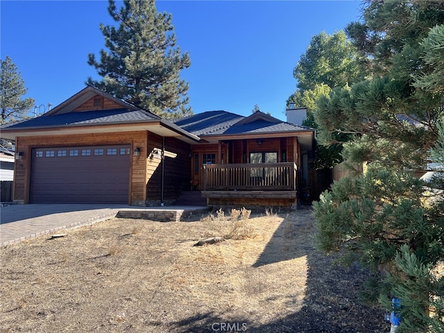 single story home featuring covered porch, decorative driveway, and a garage