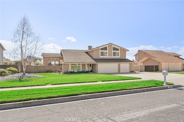 traditional-style house featuring a garage, fence, driveway, stucco siding, and a front yard