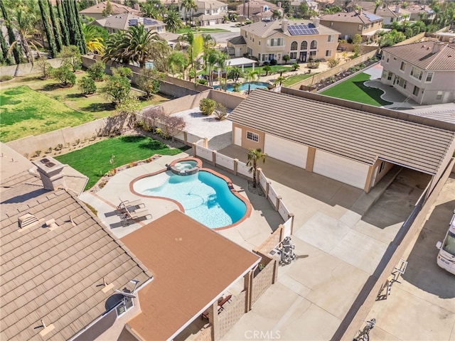 view of swimming pool featuring a patio, a pool with connected hot tub, fence, and a residential view