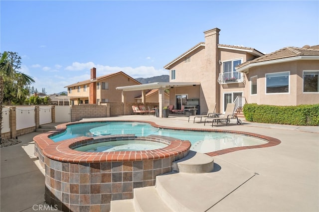 view of swimming pool with a patio area, a fenced backyard, and a pool with connected hot tub