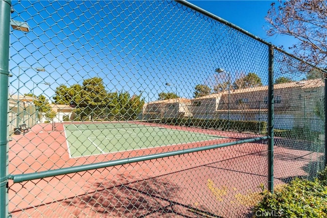 view of tennis court featuring fence