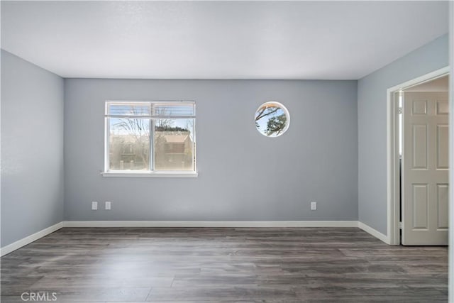 empty room with baseboards and wood finished floors