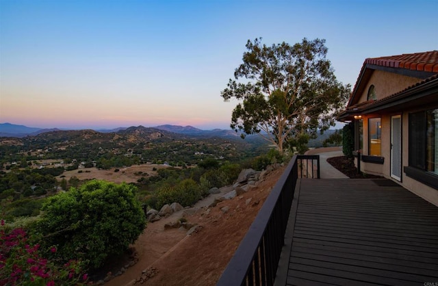 balcony at dusk featuring a mountain view