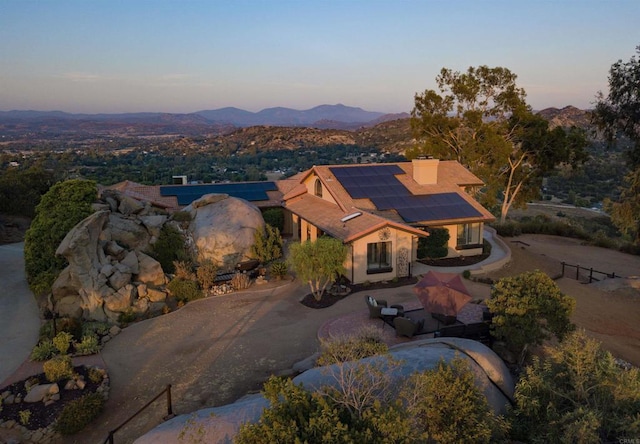 aerial view at dusk featuring a mountain view