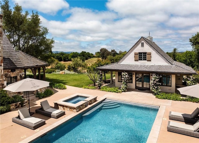 view of swimming pool with an outbuilding, a patio, a storage structure, a pool with connected hot tub, and a lawn