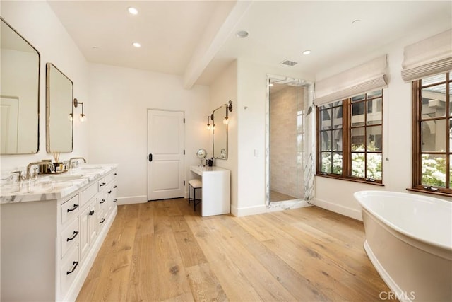 full bath with a freestanding tub, wood finished floors, visible vents, a shower stall, and double vanity