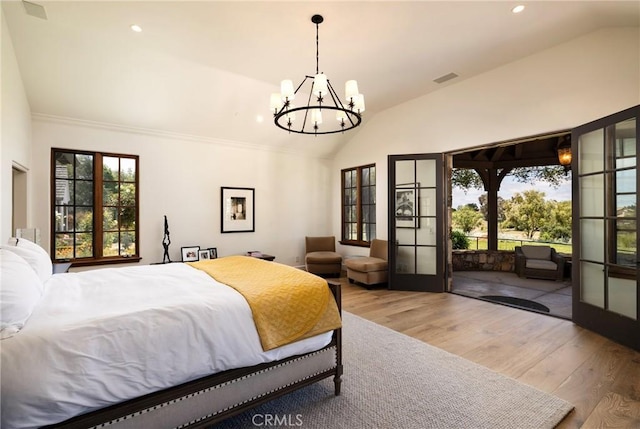 bedroom featuring lofted ceiling, access to outside, french doors, and wood finished floors