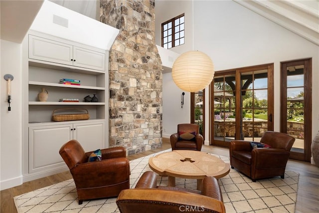 sitting room with a high ceiling, visible vents, and light wood finished floors