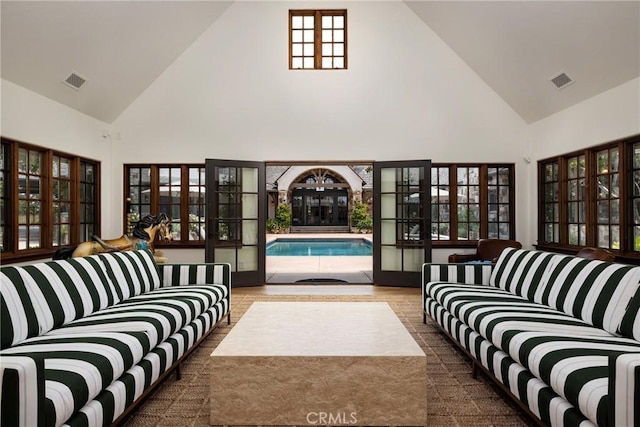 living area featuring high vaulted ceiling and visible vents