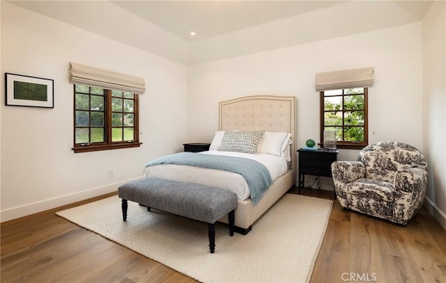 bedroom with recessed lighting, wood finished floors, and baseboards