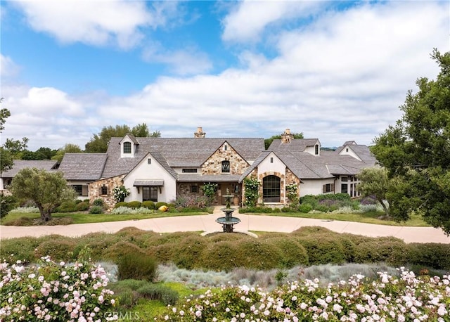 view of front of home with stone siding and driveway