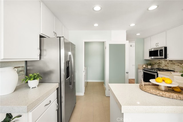 kitchen with stainless steel appliances, white cabinets, light countertops, and tasteful backsplash