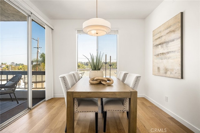 dining space with light wood-style floors and baseboards