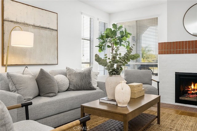 living room featuring a healthy amount of sunlight, a fireplace, and wood finished floors