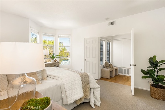 carpeted bedroom featuring visible vents