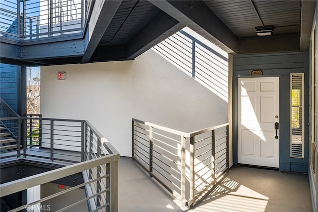 doorway to property with a balcony and stucco siding