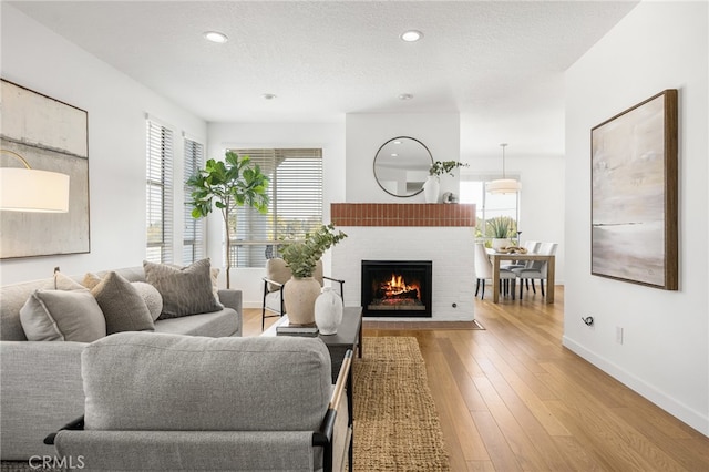 living area with a textured ceiling, hardwood / wood-style flooring, and a healthy amount of sunlight