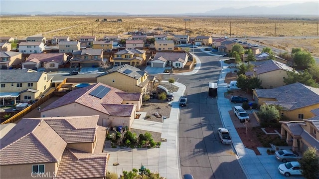 drone / aerial view with a residential view, view of desert, and a mountain view