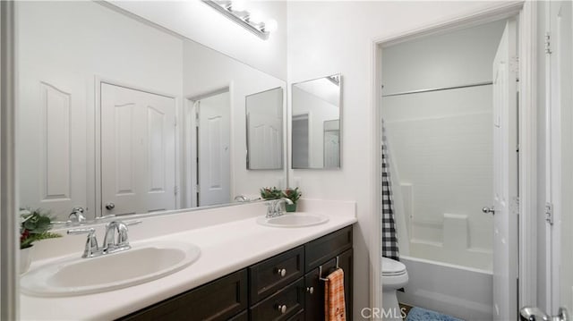 full bathroom with shower / tub combo with curtain, a sink, toilet, and double vanity