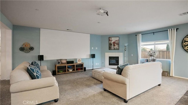 carpeted living room with baseboards, visible vents, and a glass covered fireplace