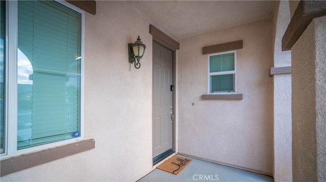 view of exterior entry featuring stucco siding