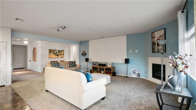 living room with carpet, visible vents, a fireplace, and baseboards