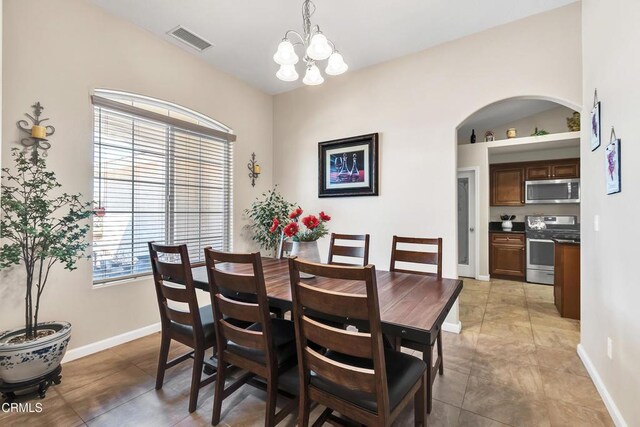 17717 Bangor Ave, Hesperia, CA 92345 - dining room featuring a chandelier, light tile patterned floors, arched walkways, and baseboards