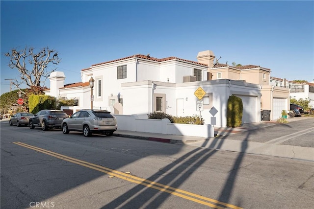 mediterranean / spanish home with a tile roof, a residential view, and stucco siding