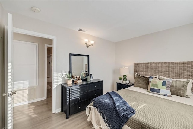 bedroom featuring light wood finished floors, baseboards, and visible vents