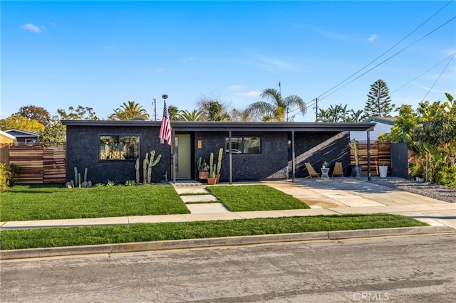 mid-century home featuring fence, a front lawn, concrete driveway, and stucco siding