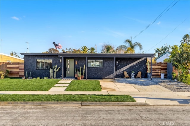 mid-century home with fence, a front lawn, and stucco siding