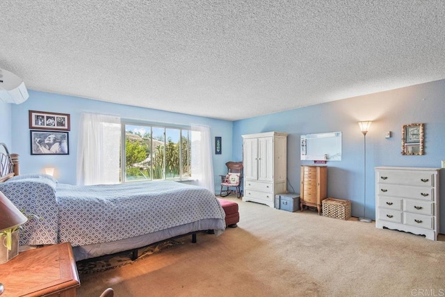 bedroom featuring carpet, a textured ceiling, and an AC wall unit