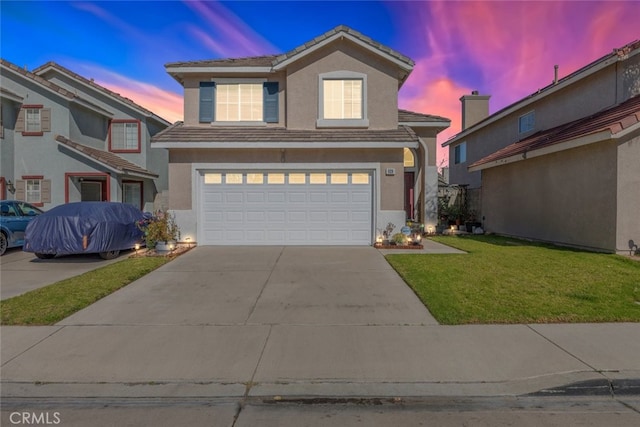 traditional-style house featuring a front lawn, a tile roof, stucco siding, a garage, and driveway