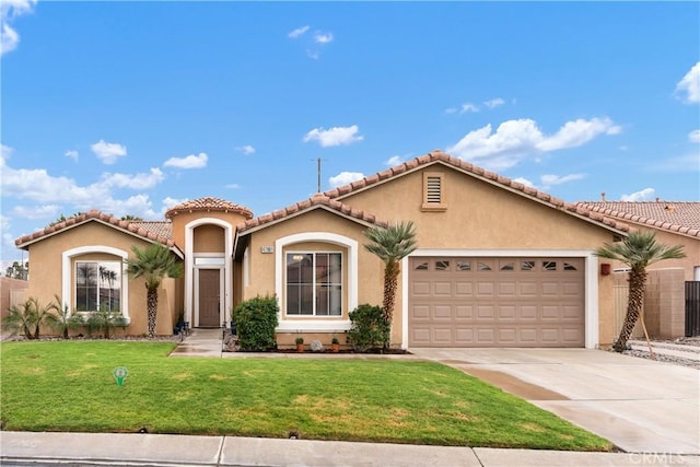 mediterranean / spanish-style home featuring a front lawn, concrete driveway, a garage, and stucco siding